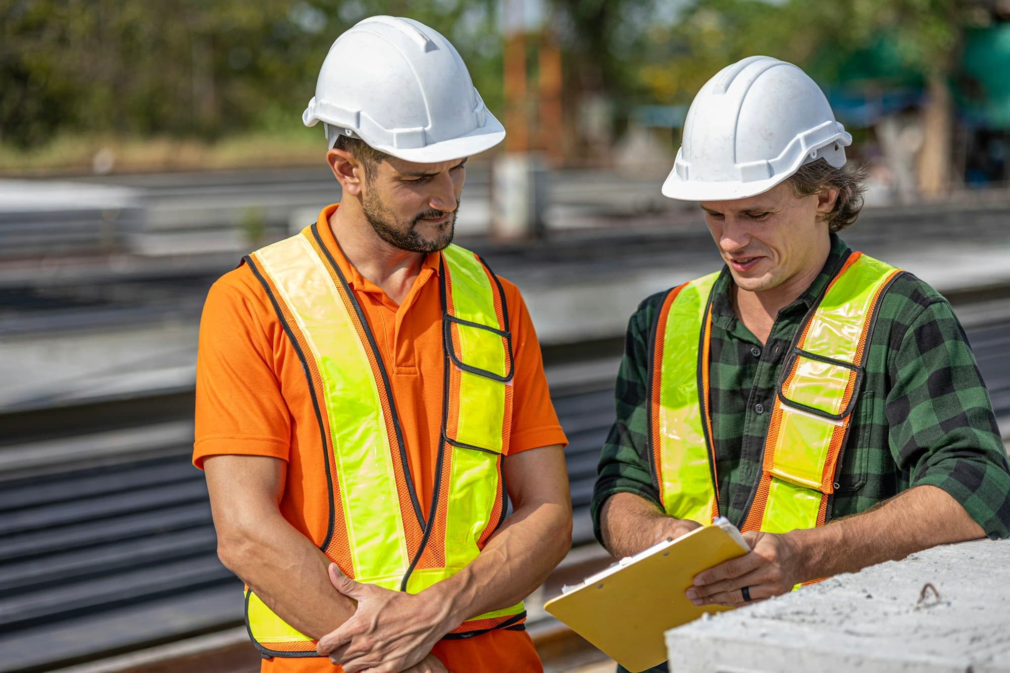 Site supervisor and worker reviewing a project checklist on site