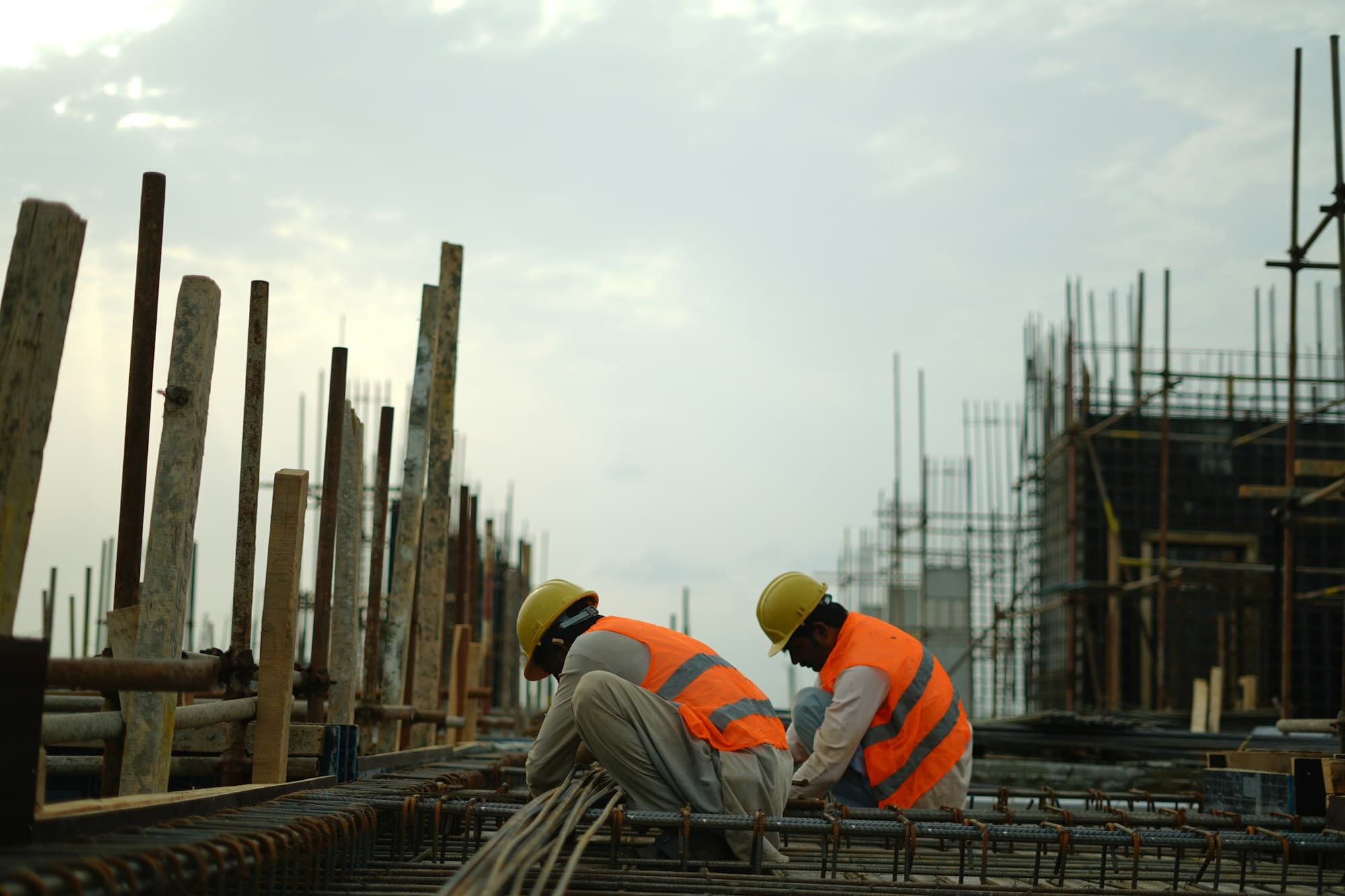 Construction labourers tying reinforcement steel on an active site