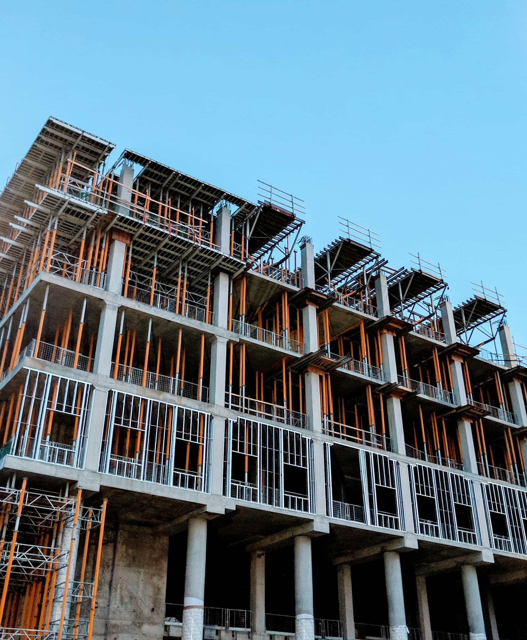 Commercial concrete-frame building under construction against a clear sky