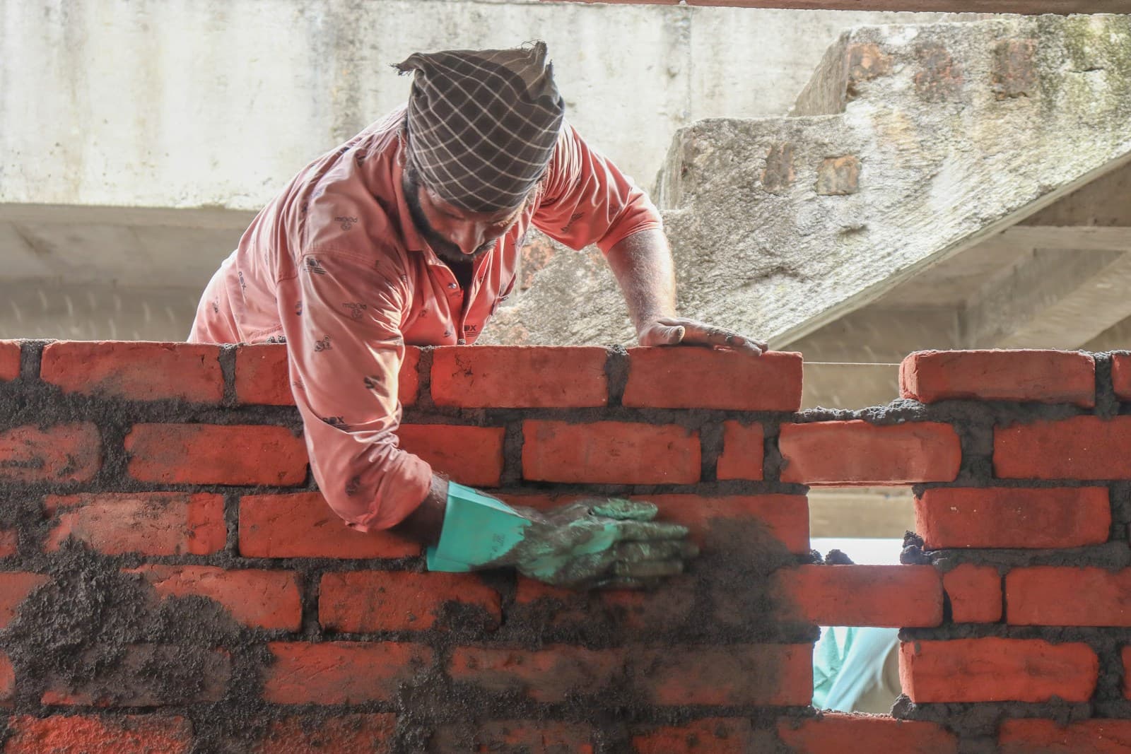 Bricklayer laying and mortaring bricks on a construction site