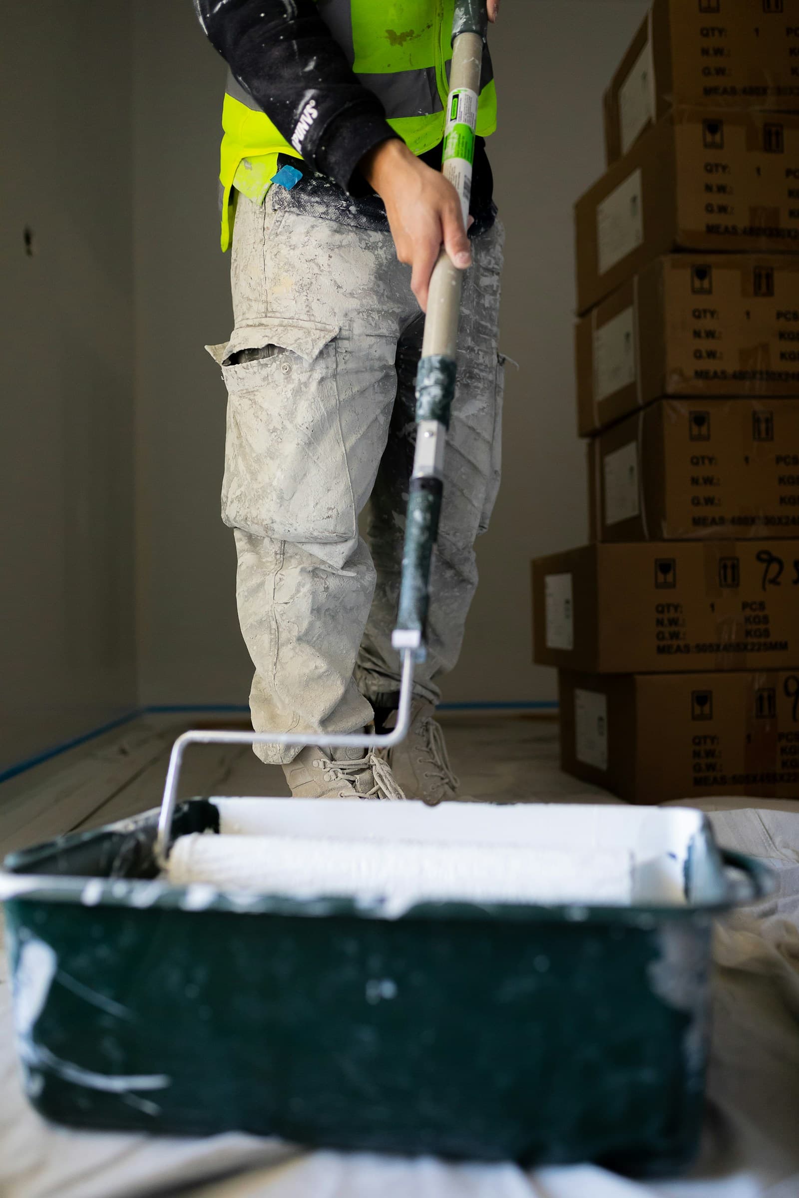 Painter rolling paint onto an interior wall on site