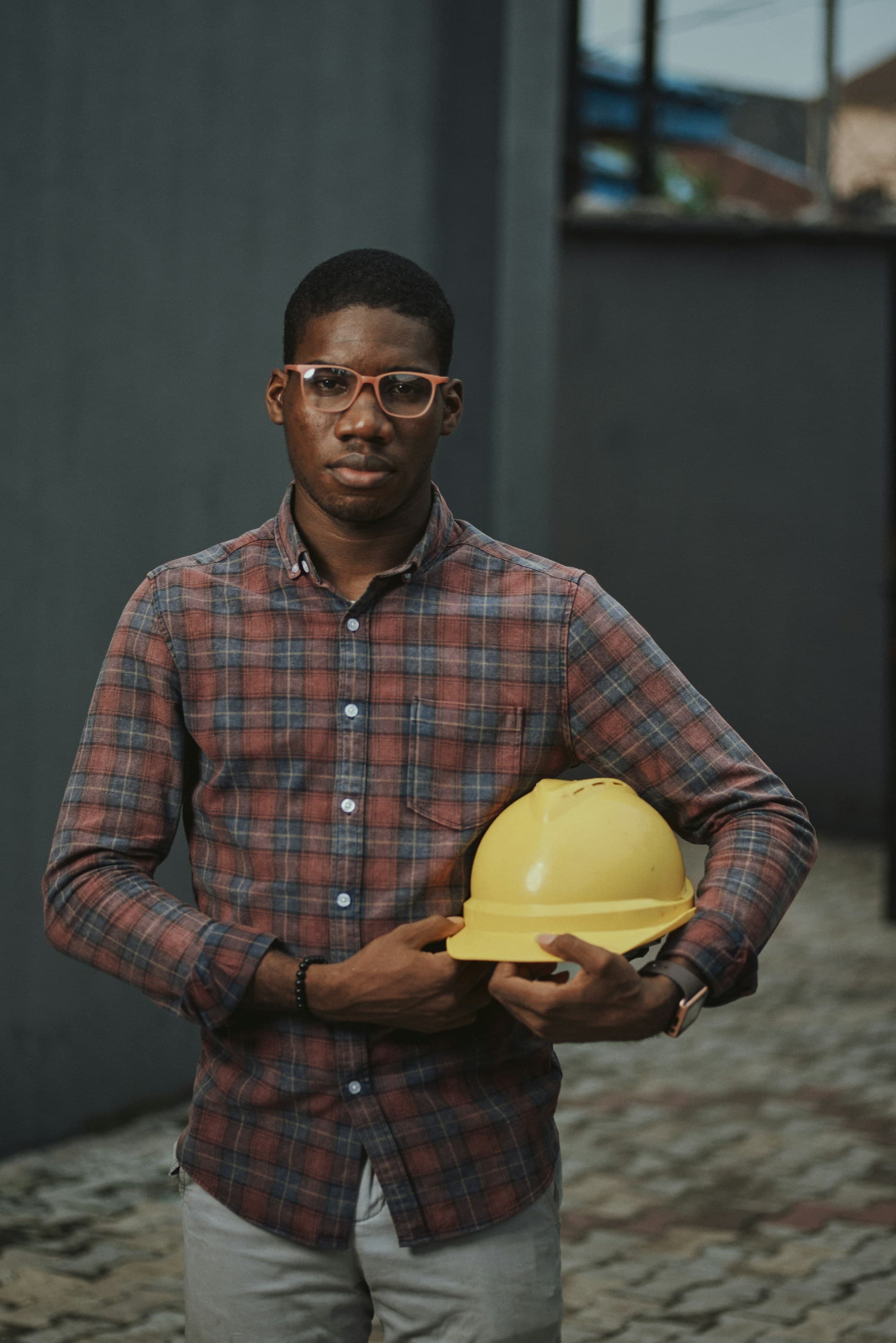 Confident construction worker holding a hard hat